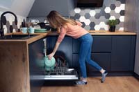 A woman loading a dishwasher