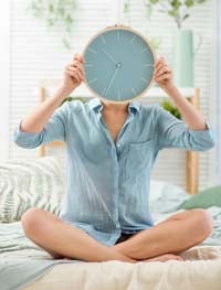 A woman holding up a clock